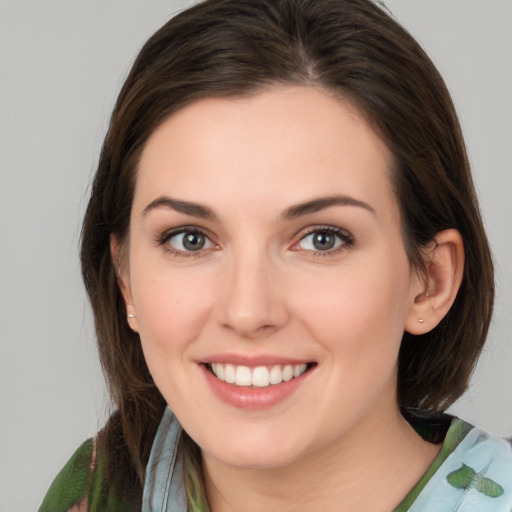 Joyful white young-adult female with medium  brown hair and green eyes