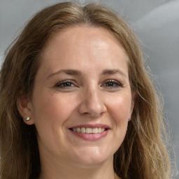 Joyful white adult female with long  brown hair and grey eyes