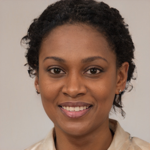 Joyful black young-adult female with medium  brown hair and brown eyes