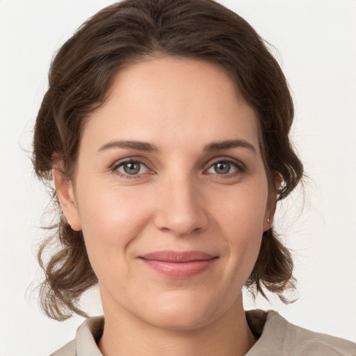 Joyful white young-adult female with medium  brown hair and grey eyes