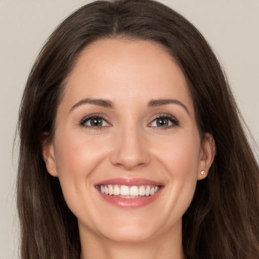 Joyful white young-adult female with long  brown hair and brown eyes