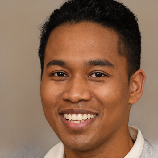 Joyful black young-adult male with short  brown hair and brown eyes