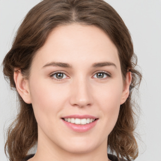 Joyful white young-adult female with medium  brown hair and green eyes