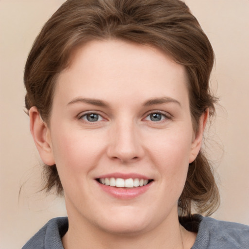 Joyful white young-adult female with medium  brown hair and grey eyes