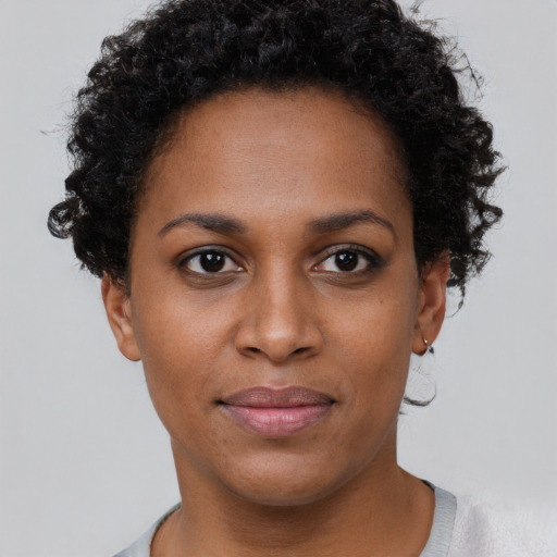 Joyful black young-adult female with short  brown hair and brown eyes