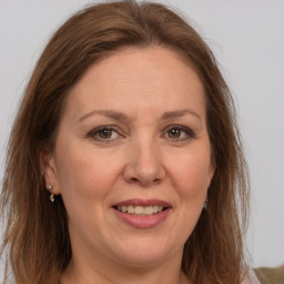 Joyful white adult female with long  brown hair and green eyes