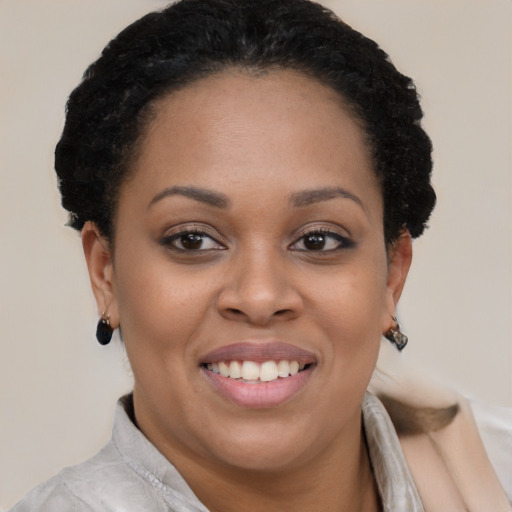 Joyful black young-adult female with short  brown hair and brown eyes
