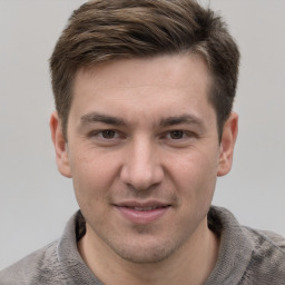 Joyful white young-adult male with short  brown hair and grey eyes