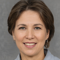 Joyful white adult female with medium  brown hair and grey eyes