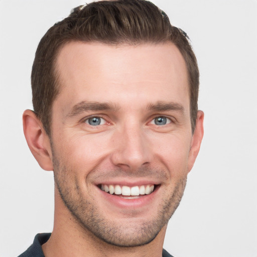 Joyful white young-adult male with short  brown hair and grey eyes