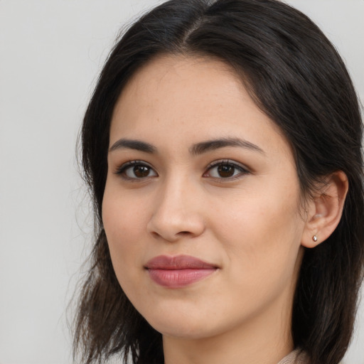 Joyful latino young-adult female with long  brown hair and brown eyes