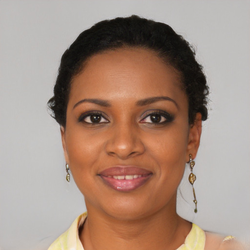 Joyful black young-adult female with long  brown hair and brown eyes