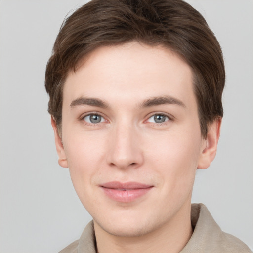 Joyful white young-adult male with short  brown hair and grey eyes