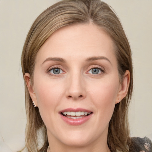 Joyful white young-adult female with long  brown hair and blue eyes