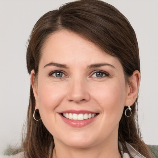 Joyful white young-adult female with medium  brown hair and grey eyes