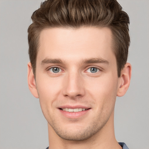 Joyful white young-adult male with short  brown hair and grey eyes