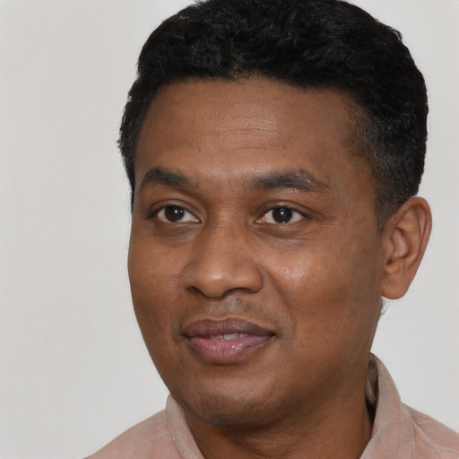 Joyful black young-adult male with short  black hair and brown eyes
