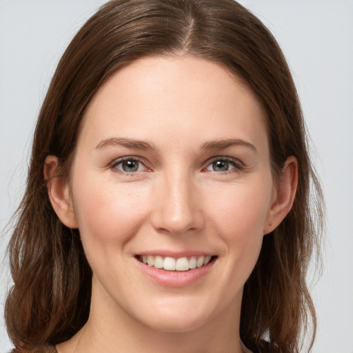 Joyful white young-adult female with medium  brown hair and grey eyes