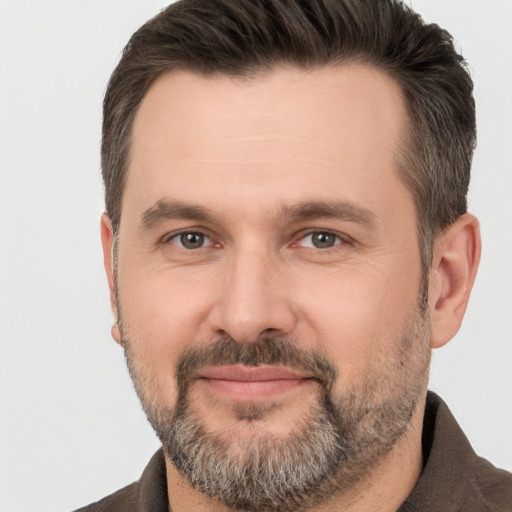 Joyful white adult male with short  brown hair and brown eyes