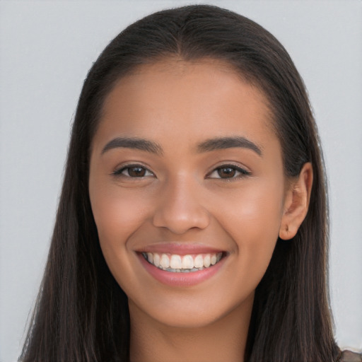 Joyful latino young-adult female with long  brown hair and brown eyes