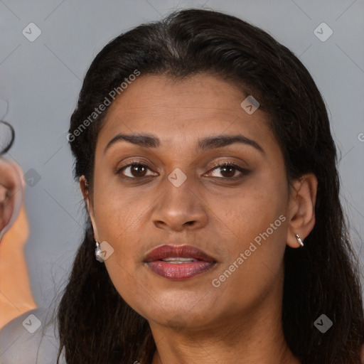 Joyful latino adult female with long  brown hair and brown eyes