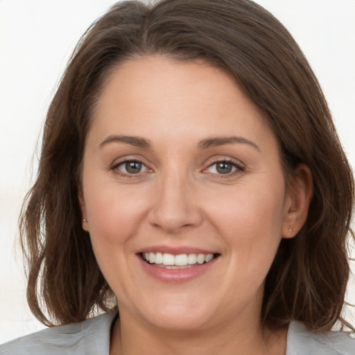 Joyful white young-adult female with medium  brown hair and grey eyes