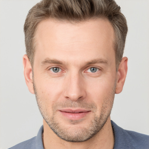 Joyful white adult male with short  brown hair and grey eyes