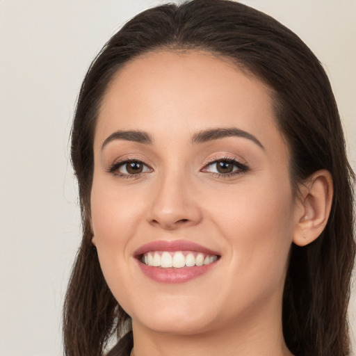 Joyful white young-adult female with long  brown hair and brown eyes