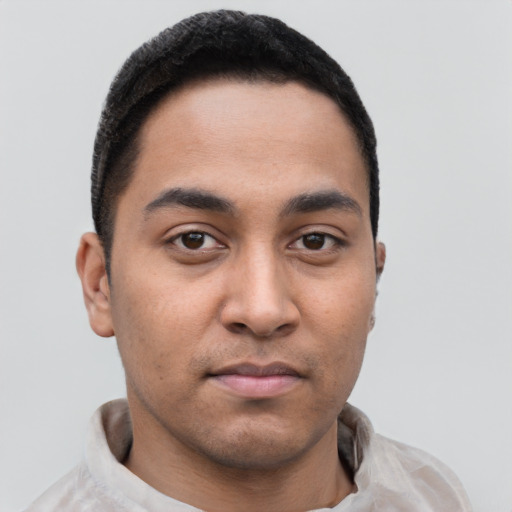 Joyful latino young-adult male with short  black hair and brown eyes