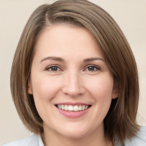 Joyful white young-adult female with medium  brown hair and green eyes