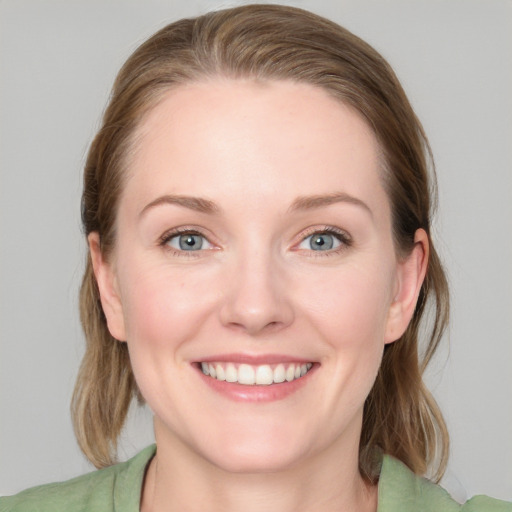 Joyful white young-adult female with medium  brown hair and blue eyes