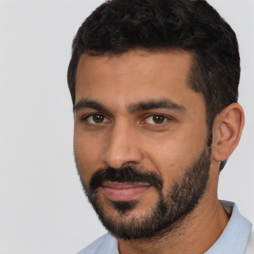 Joyful latino young-adult male with short  black hair and brown eyes