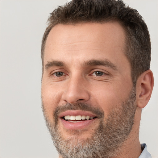 Joyful white adult male with short  brown hair and brown eyes