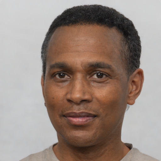 Joyful black adult male with short  black hair and brown eyes
