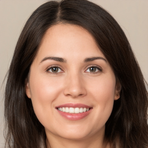 Joyful white young-adult female with long  brown hair and brown eyes