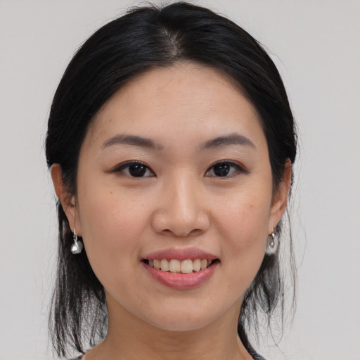 Joyful asian young-adult female with medium  brown hair and brown eyes