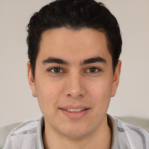Joyful latino young-adult male with short  brown hair and brown eyes