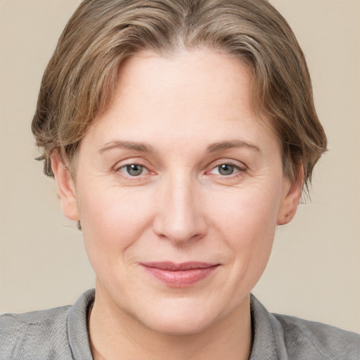 Joyful white young-adult female with short  brown hair and grey eyes