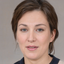 Joyful white adult female with medium  brown hair and grey eyes