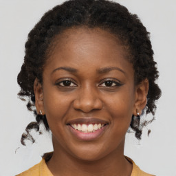 Joyful black young-adult female with medium  brown hair and brown eyes