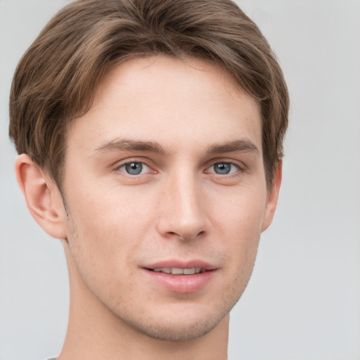 Joyful white young-adult male with short  brown hair and grey eyes