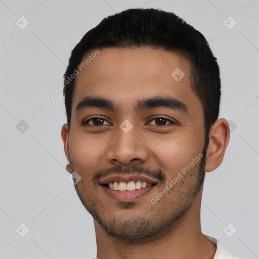 Joyful latino young-adult male with short  black hair and brown eyes