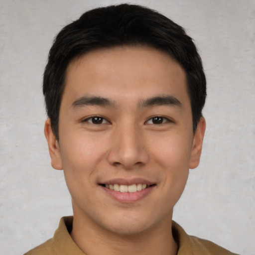 Joyful asian young-adult male with short  brown hair and brown eyes