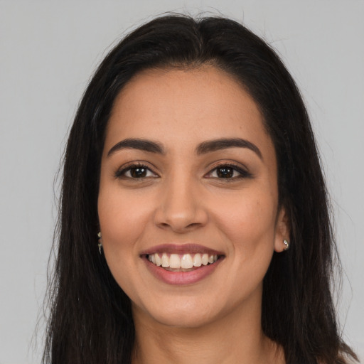 Joyful latino young-adult female with long  brown hair and brown eyes