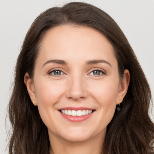 Joyful white young-adult female with long  brown hair and grey eyes