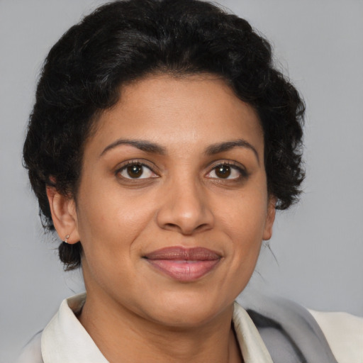 Joyful latino adult female with short  brown hair and brown eyes