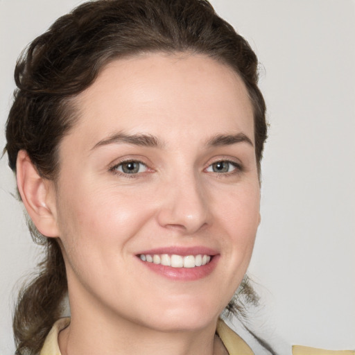 Joyful white young-adult female with medium  brown hair and grey eyes