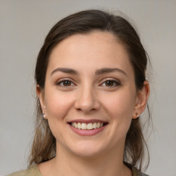 Joyful white young-adult female with medium  brown hair and grey eyes