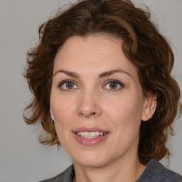 Joyful white adult female with medium  brown hair and blue eyes