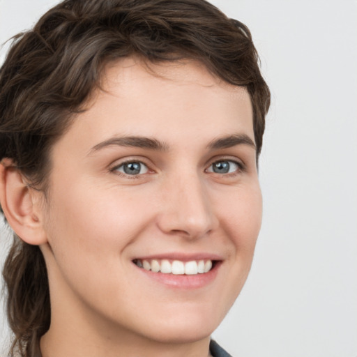 Joyful white young-adult female with short  brown hair and grey eyes